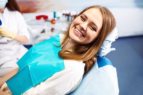 Patient sitting in a dental chair during a professional teeth whitening consultation in Maple
