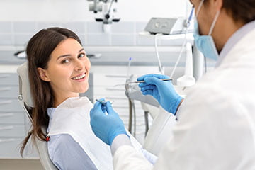 Dental patient consulting with a dentist about custom take-home whitening trays for at-home treatment