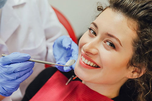 Dentist performing a professional teeth whitening procedure during a treatment appointment