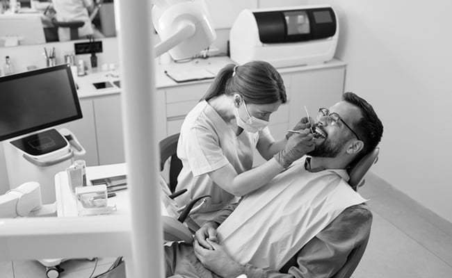 Dentist examining a patient during a consultation for Teeth in a Day and All-on-4 dental implant treatment.