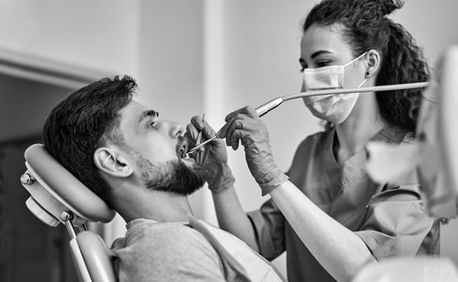 Dental hygienist performing a professional dental cleaning to remove plaque and support oral health.