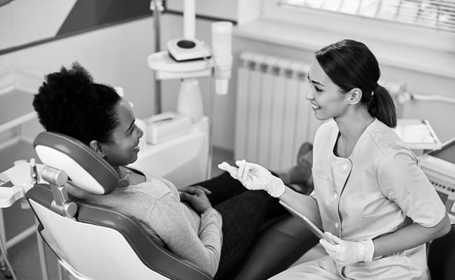 Dentist discussing filling replacement options with a patient during a consultation at a dental clinic.