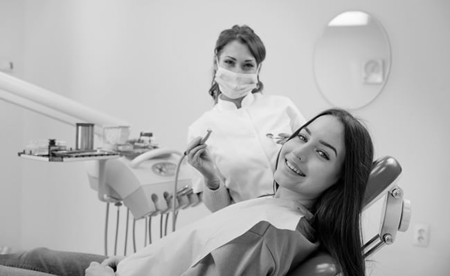 Patient smiling after receiving a dental restoration treatment with onlays at a dental clinic.