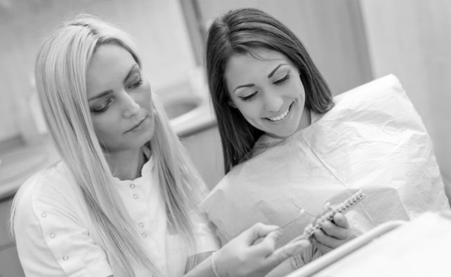 Dentist discussing porcelain veneer treatment options with a patient during a cosmetic dentistry consultation.