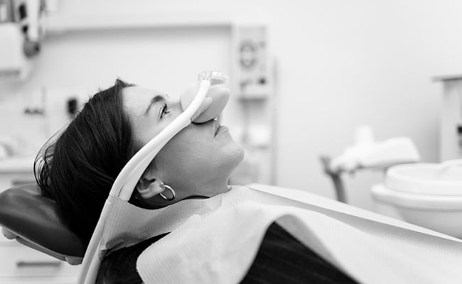 Patient seated comfortably in a dental chair during a sedation dentistry appointment at a dental clinic.