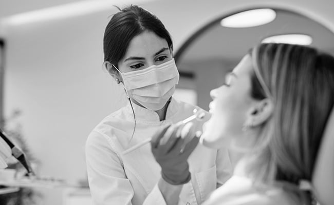 Dentist evaluating a patient's smile and discussing cosmetic treatment options during a smile makeover consultation.