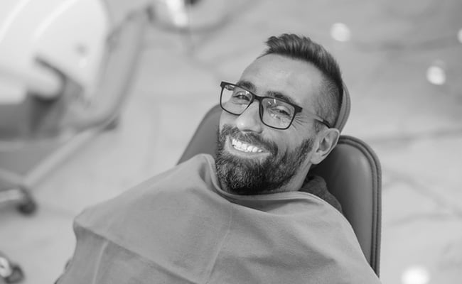 Patient smiling during a teeth whitening consultation at a dental clinic.