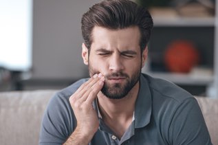 Man Holding Cheek in Pain