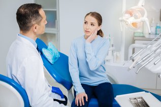 Woman holding her jaw because of TMJ disorder symptoms and jaw pain in Maple, ON